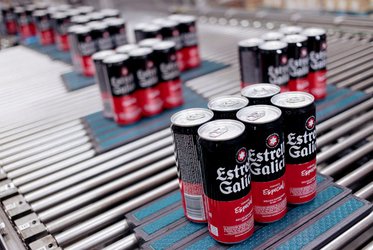 Das Bild zeigt mehrere Sechserpackungen von Estrella Galicia Dosen auf einem Förderband in einer Abfüllanlage.