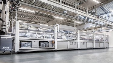 Das Bild zeigt eine moderne KHS-Verpackungsmaschine in einer industriellen Umgebung, die für die Verpackung von Getränken verwendet wird.