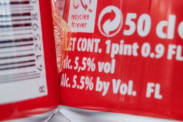 Das Bild zeigt einen Nahaufnahmeausschnitt eines Etiketts auf einer Getränkedose, das den Alkoholgehalt von 5,5 % Volumen sowie weitere Informationen wie die Füllmenge von 50 cl angibt.